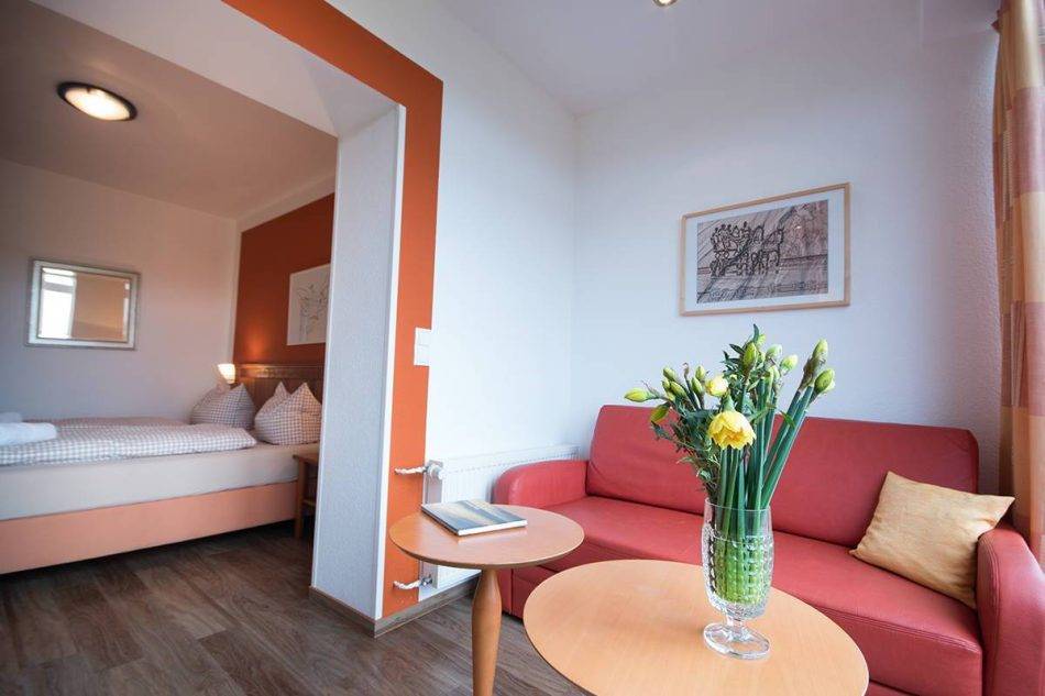 Wohnbereich Mit Großer Fensterfront, Sofa Und Tisch, EG Des Haupthauses Im Doppelzimmer Eins Im Hotel Nige Hus Auf Der Insel Neuwerk.
