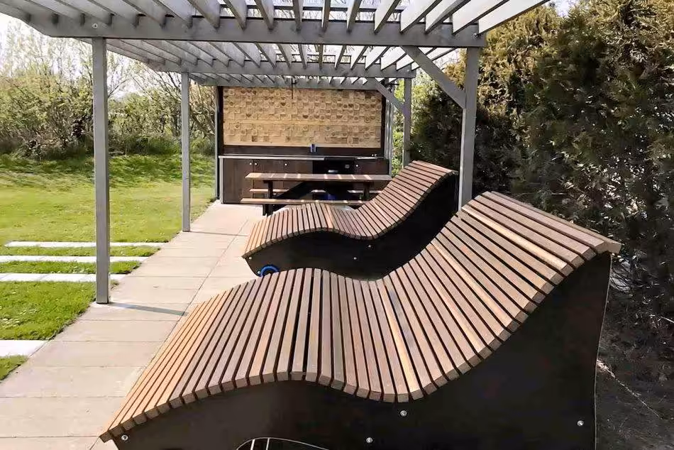 A Close-up Of The Curved Wooden Loungers That Can Seat 2-3 People.