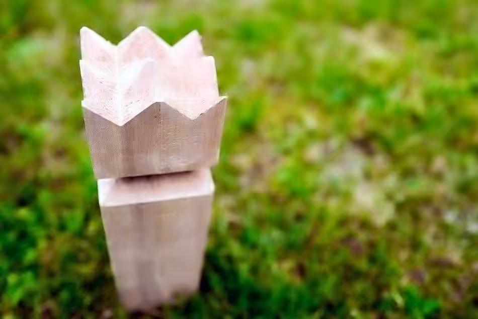 Eine Nahaufnahme Des Königs In Einem Kubb-Spiel, Der Stolz Auf Dem Rasen Steht.